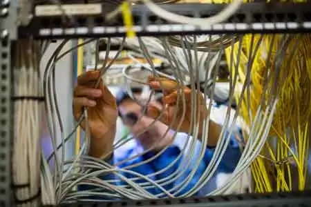 engineer inspecting cables in cabinet